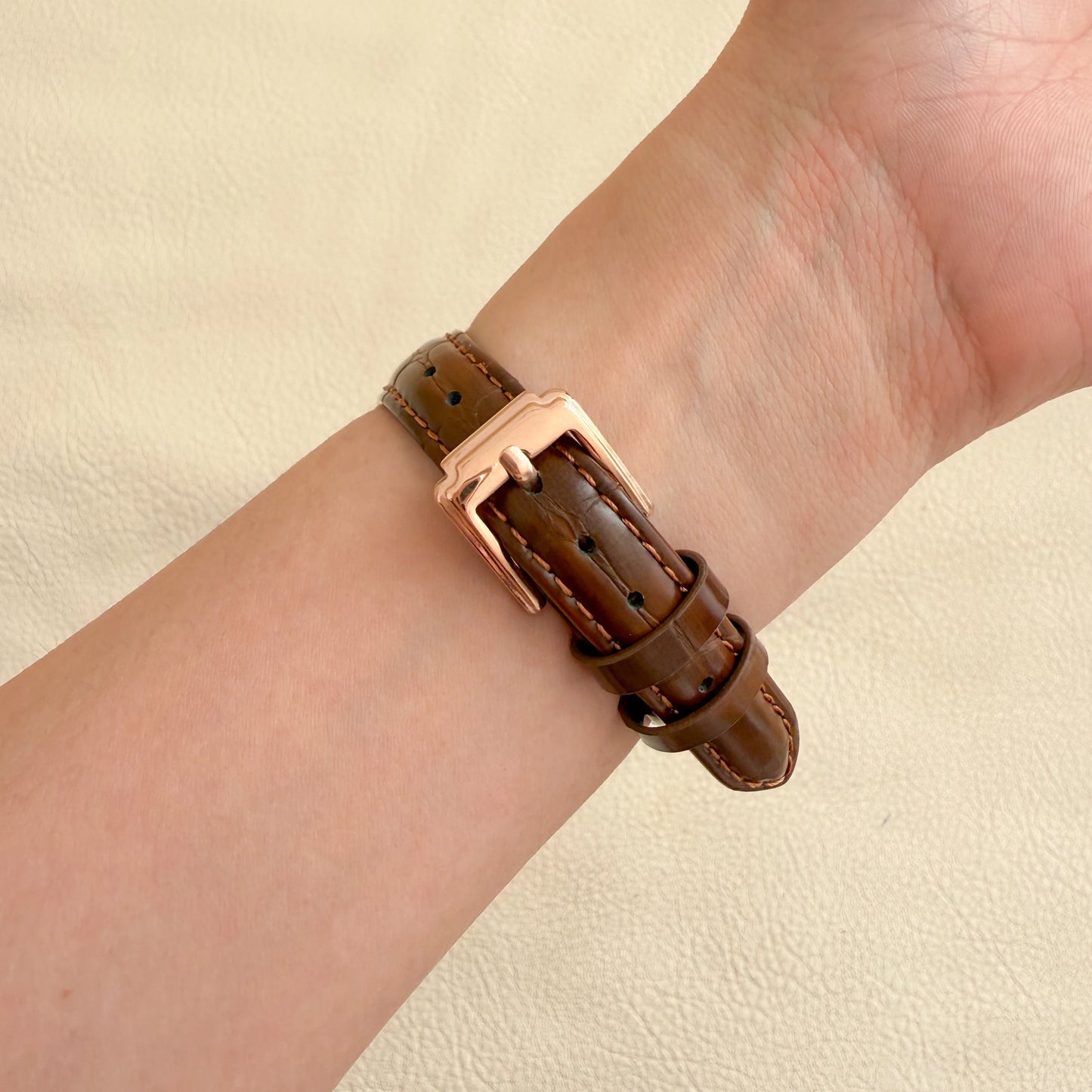 Brown leather bracelet with rose gold clasp on a wrist