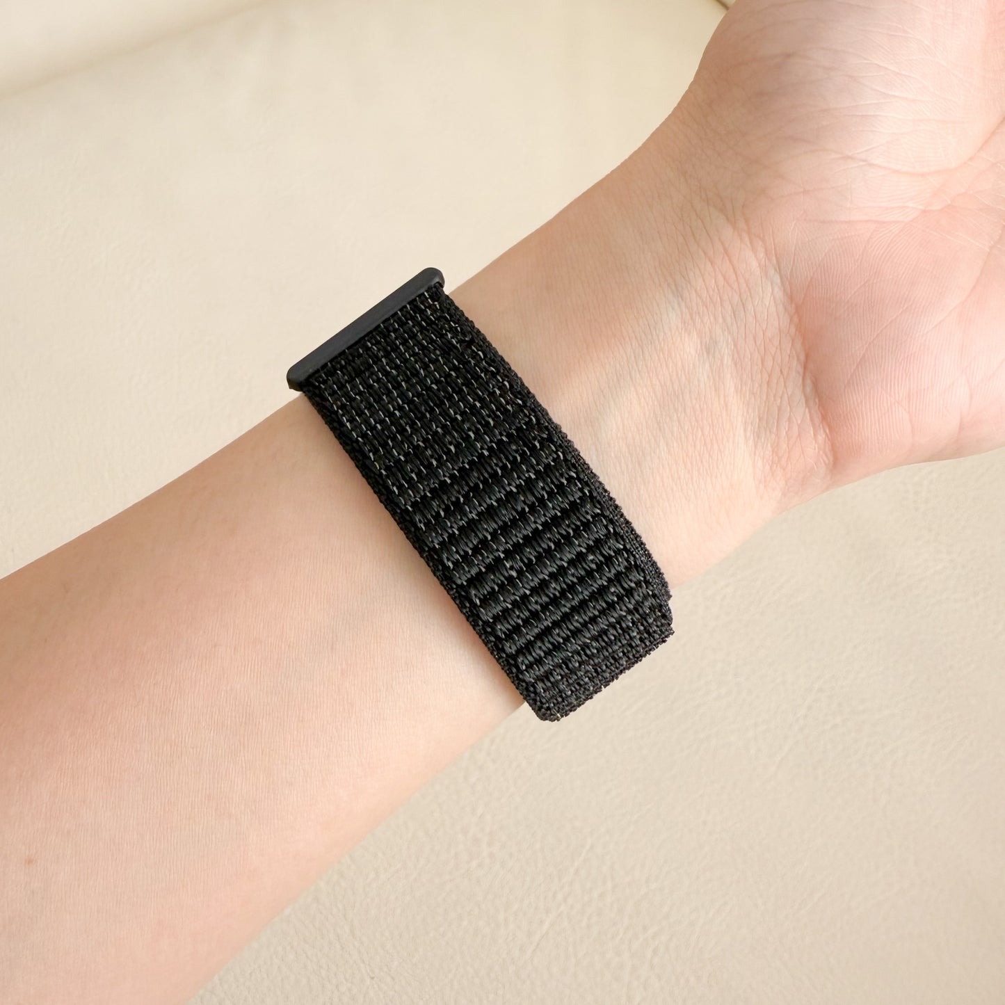 Black woven Soft Nylon Apple Watch Loop - Black on a wrist with a neutral background