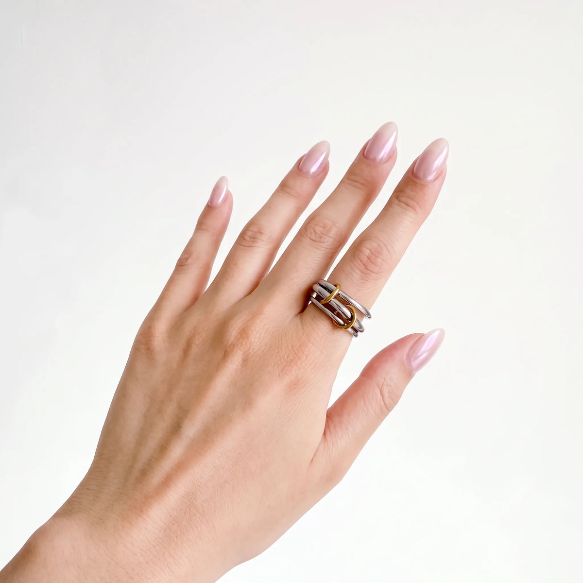 Sloane Linked Ring worn on a woman's hand, silver bands with gold loops, side angle