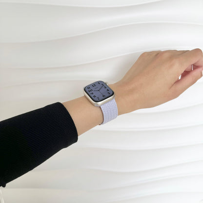 Cloud Nylon Apple Watch Band in lavender worn on wrist against a white wavy wall