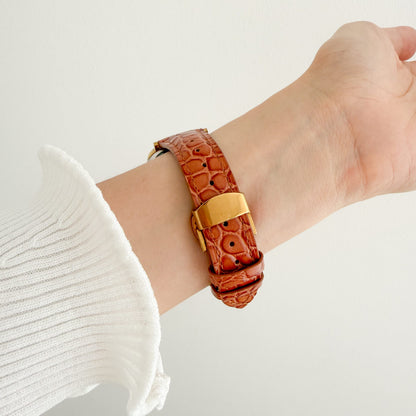 Alligator Apple Watch Band in brown worn on wrist with a white knit sleeve, angled view