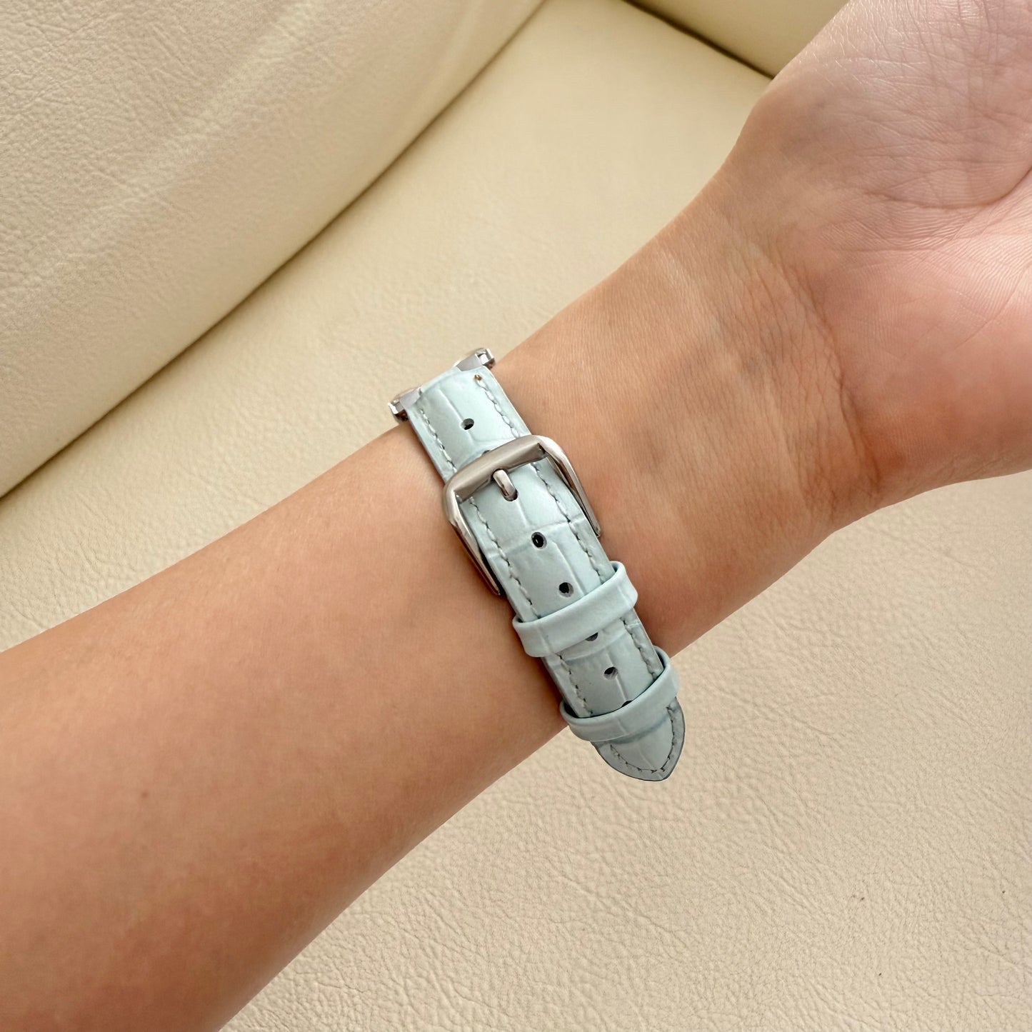 Light blue leather APPLE watch strap on a wrist 