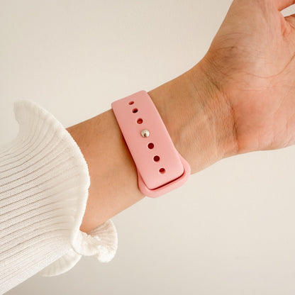 Classic Silicone Pink Apple Watch Band worn on wrist with a white knit sleeve, angled view