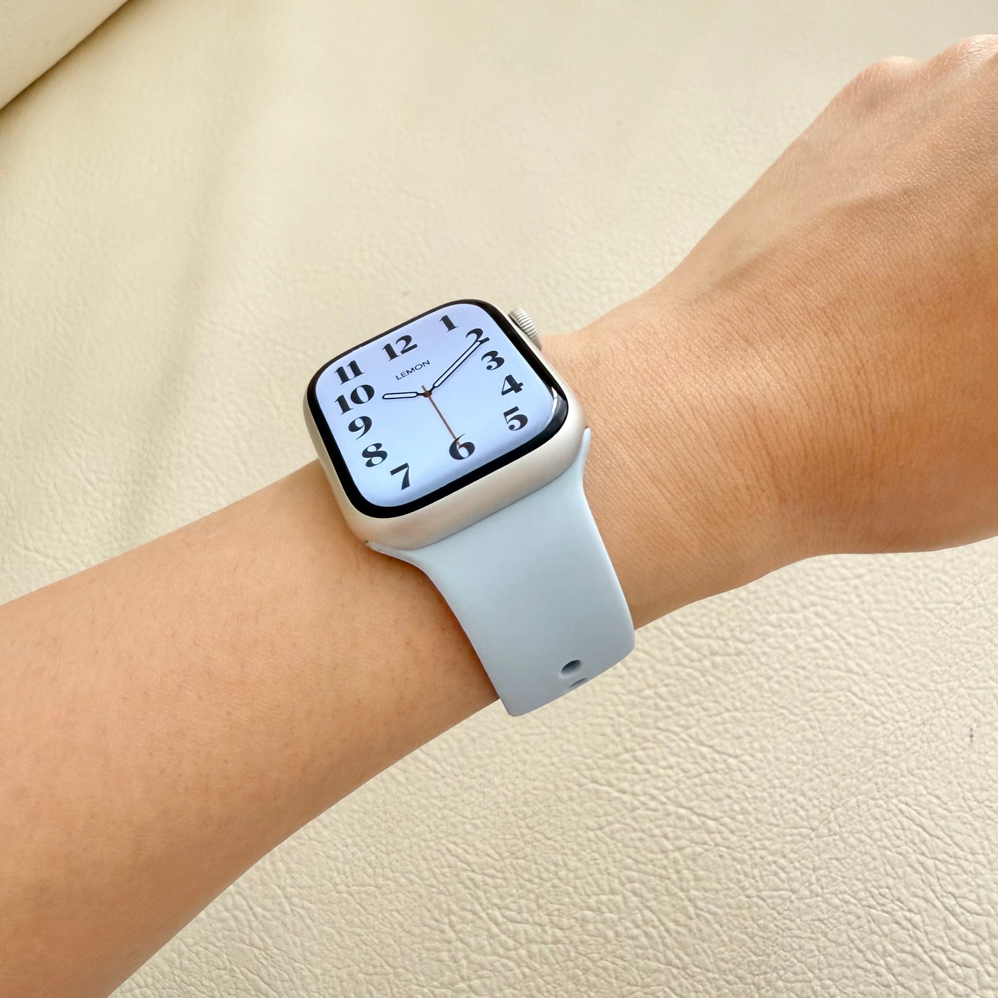 Smartwatch with a light blue strap on a wrist 