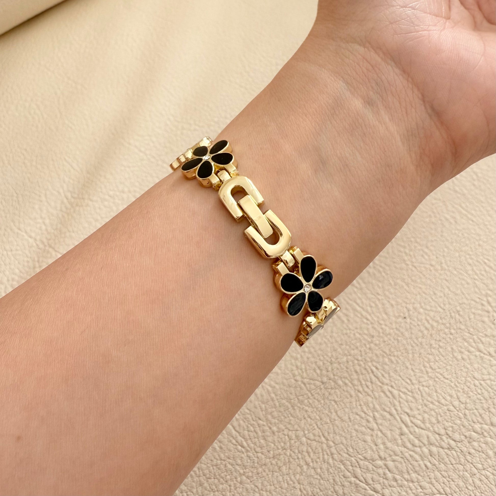 gold APPLE watch bracelet with floral on wrist