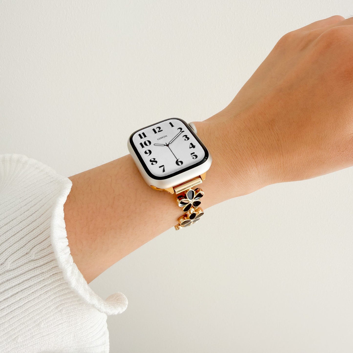 Wrist wearing a gold watch APPLE women