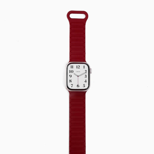 A red silicone band for an Apple Watch with a magnetic loop attachment.