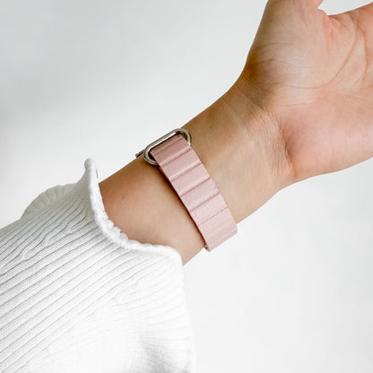 Slim Snap Loop Pink Apple Watch Band worn on wrist with a white knit sleeve, angled view