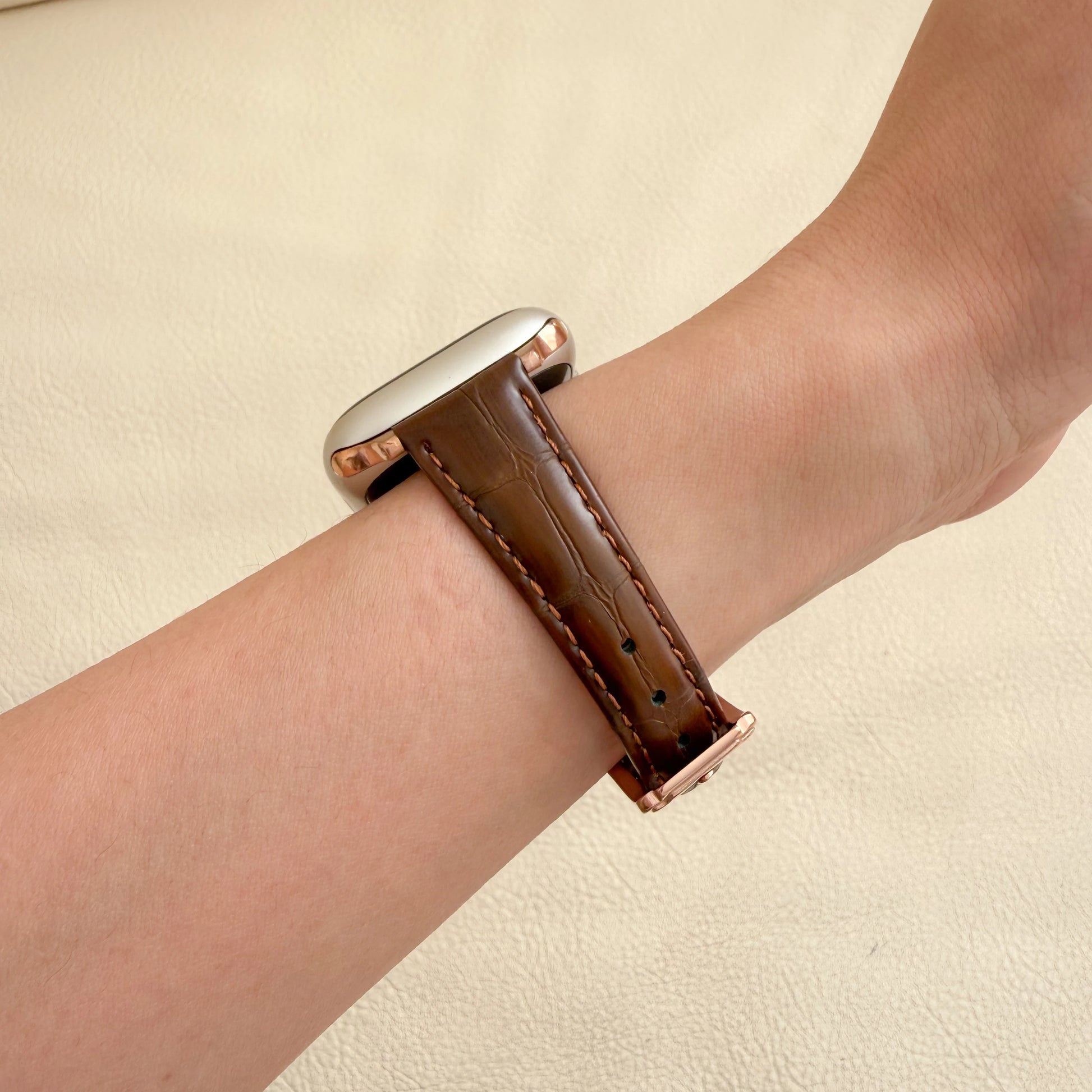 Smartwatch with a brown leather strap on a wrist WOMEN