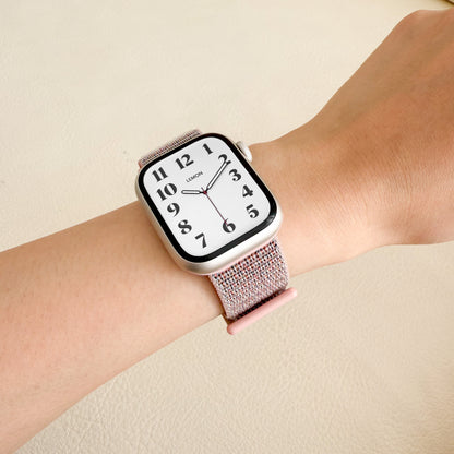 Soft Nylon Apple Watch Loop in dark pink worn on wrist against a cream background, watch face view