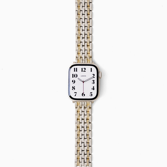 A square-faced analog watch with a white dial and a two-tone metal link band in silver and gold