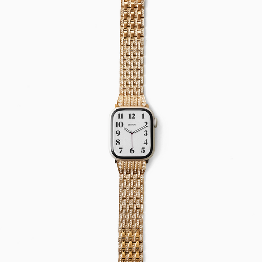 Gold watch with a white face on a white background