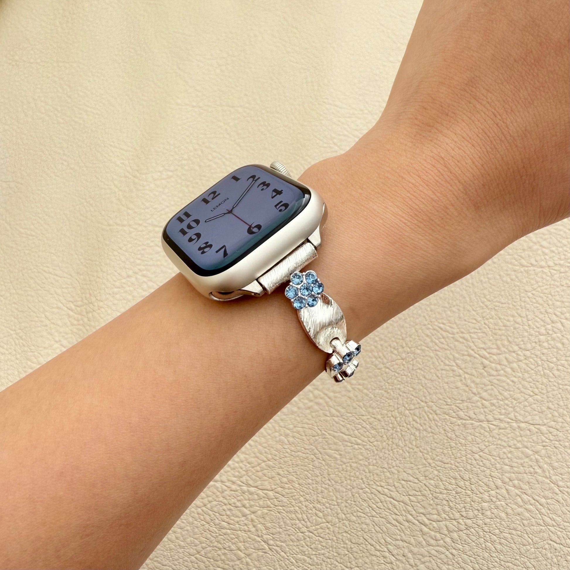 Silver  smartwatch with decorative band on a wrist