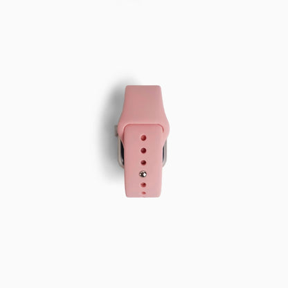 Classic Silicone Apple Watch Band in pink, rolled up with pin closure on white