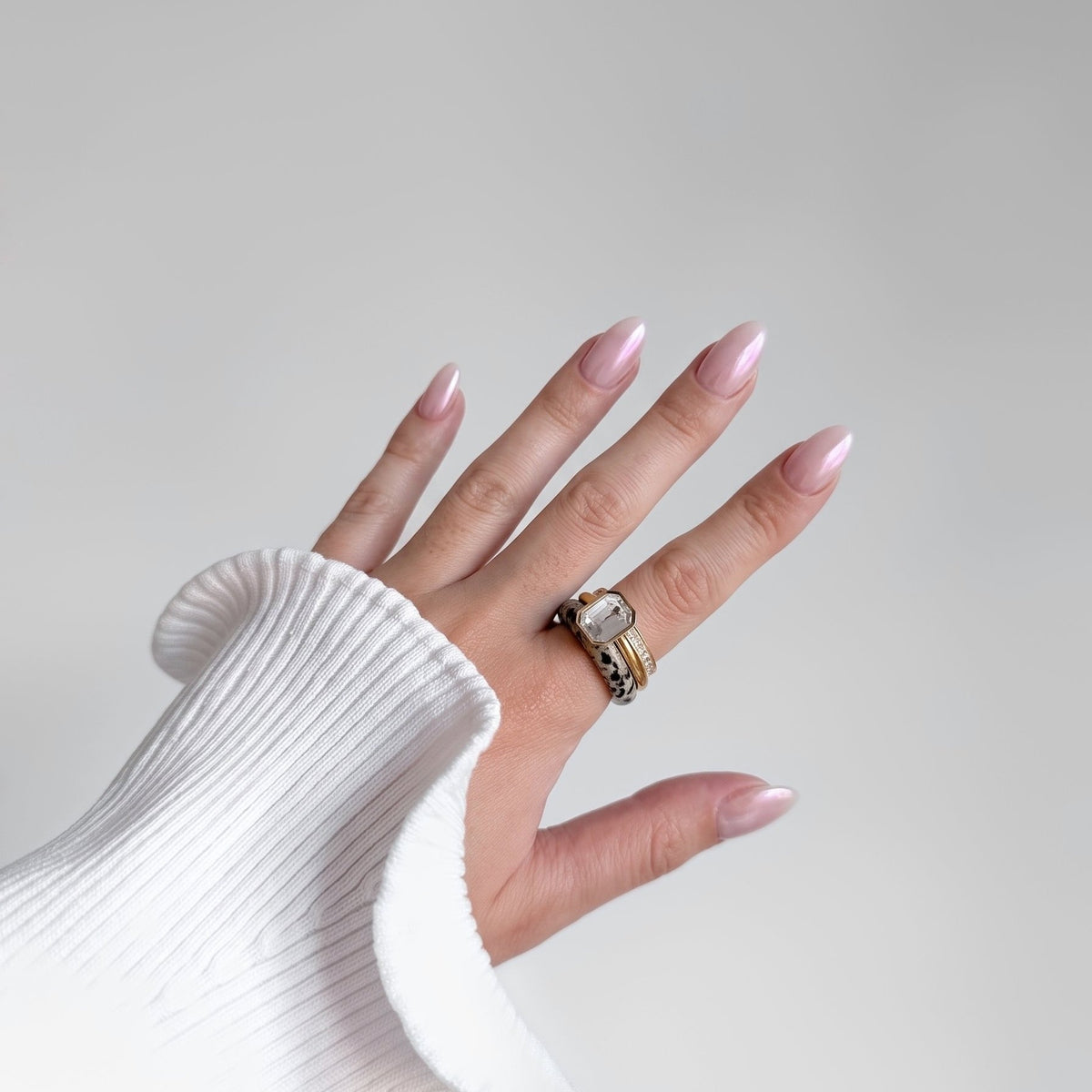Cookies & Cream Ring Set worn as a full stack on one finger with a white ribbed knit sleeve