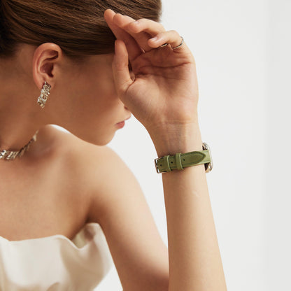 Woman wearing the Classic Leather Apple Watch Band in prairie green, hand raised to her forehead