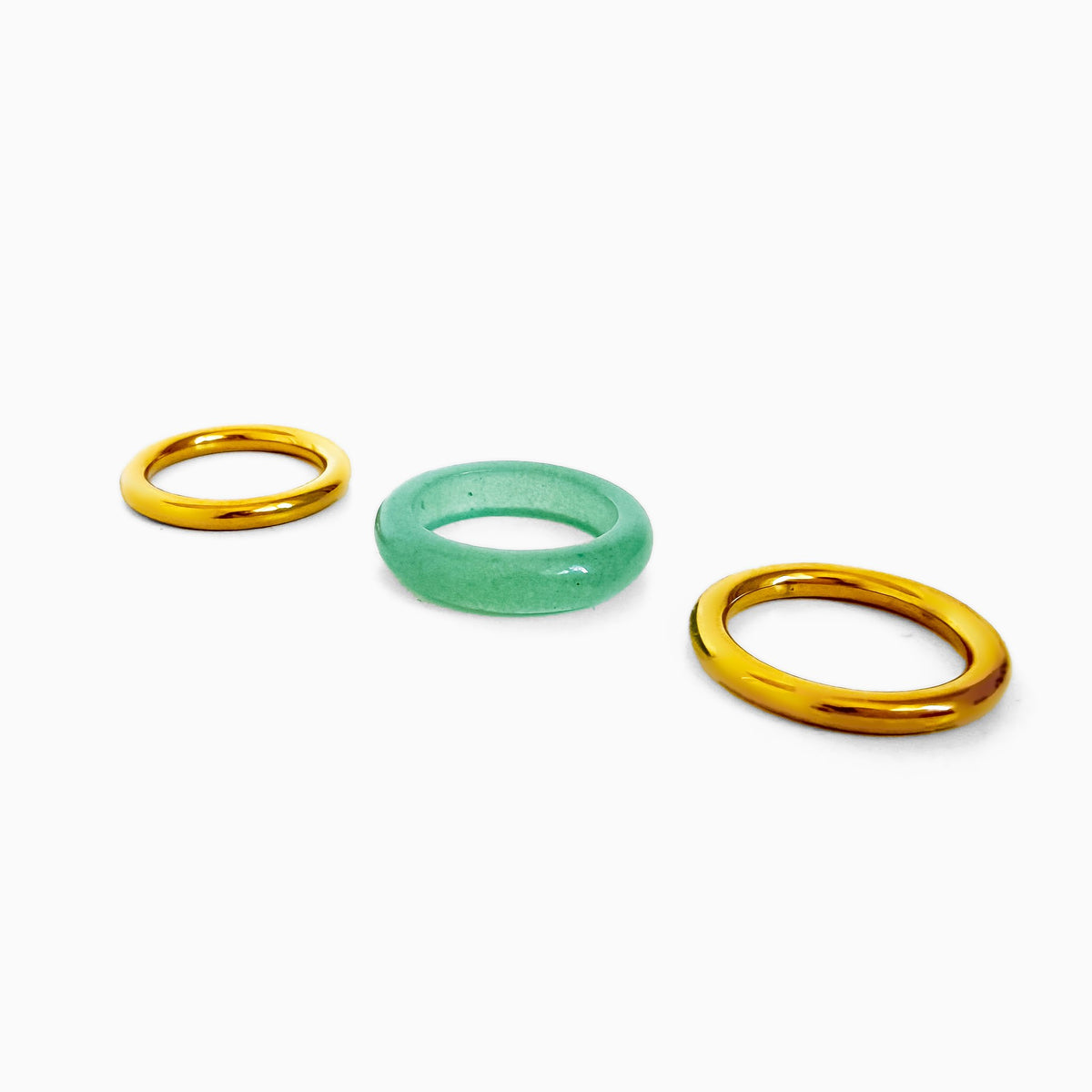 Matcha Ring Set laid out as three separate rings: two smooth gold-tone rings and a pale green stone band