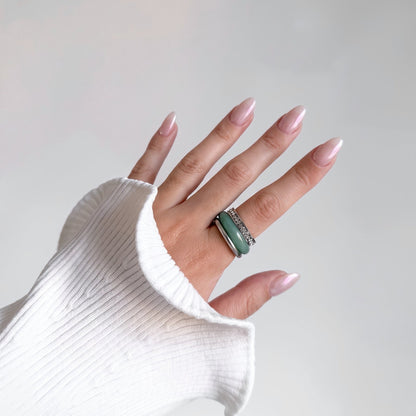 Mint Frost Ring Set worn on a woman's hand, silver rhinestone row band, green aventurine band and silver ring, white ribbed knit sleeve