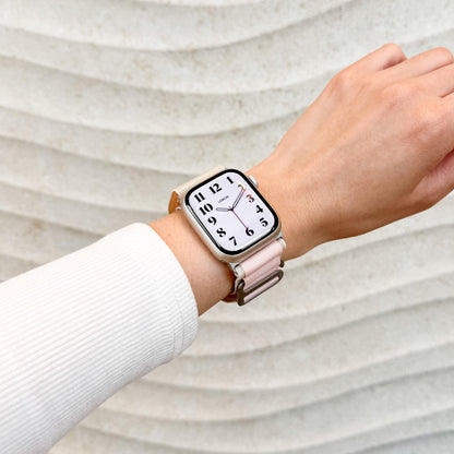 Mountain Nylon Apple Watch Band in starlight and pink worn on wrist with a white knit sleeve, watch face view
