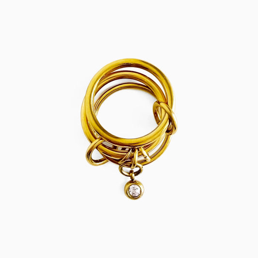 Poppy Charm Ring, slim gold-tone bands linked together with a crystal drop charm, top view