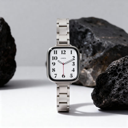 Slim Moon Apple Watch Band in starlight stainless steel standing beside black lava rock