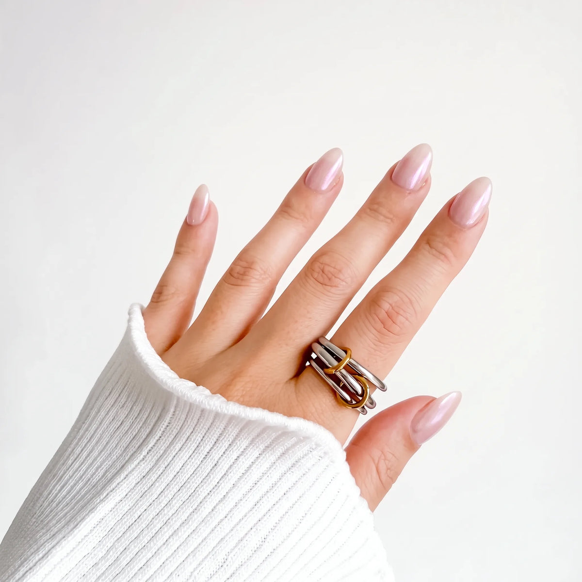 Sloane Linked Ring worn on a woman's hand beside a white ribbed knit sleeve