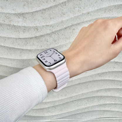 Magnetic Snap Silicone Apple Watch Band in light pink worn on wrist with a white knit sleeve, watch face view