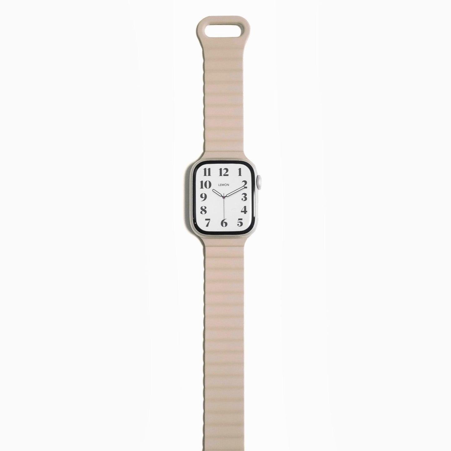 An Apple Watch with a beige magnetic snap rubber band.