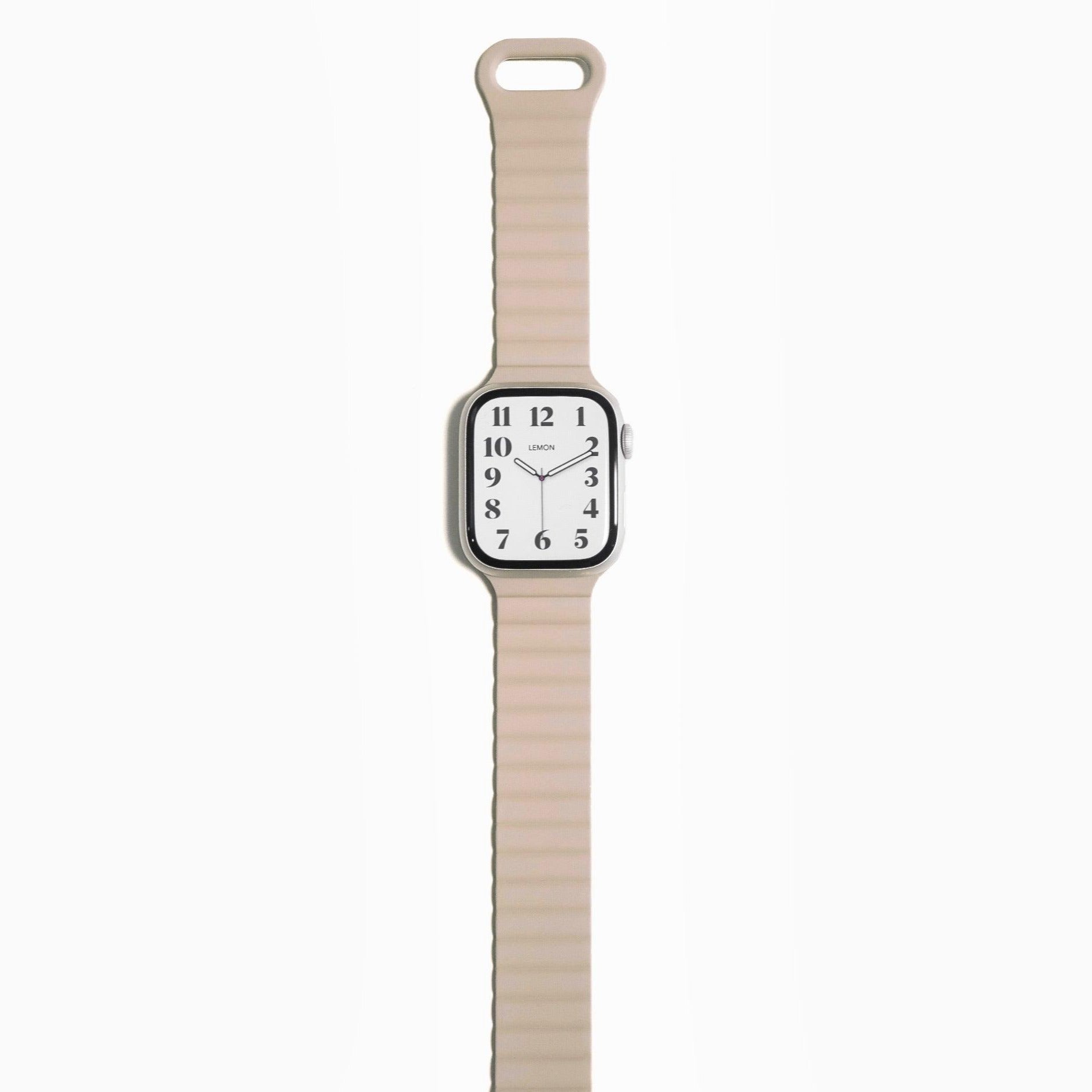 An Apple Watch with a beige magnetic snap rubber band.