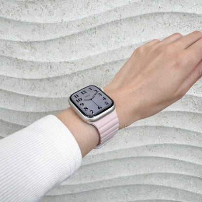 Magnetic Snap Silicone Apple Watch Band in pink and starlight worn on wrist with a white knit sleeve, watch face view