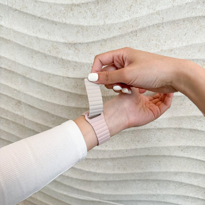 Hand fastening the Magnetic Snap Silicone Apple Watch Band in pink and starlight on a wrist