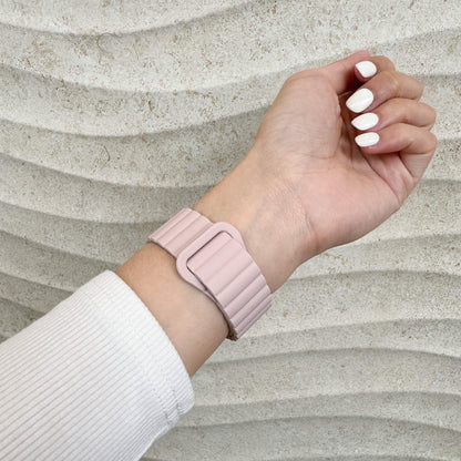 Magnetic Snap Silicone Apple Watch Band in pink and starlight worn on a raised wrist, side view
