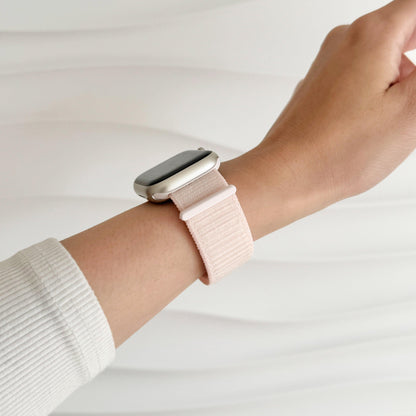 Soft Nylon Apple Watch Loop in light pink worn on wrist with a white knit sleeve, side view