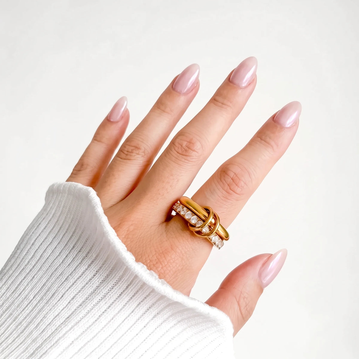 Sprinkled Donut Ring in gold worn on a woman's hand with a white ribbed knit sleeve