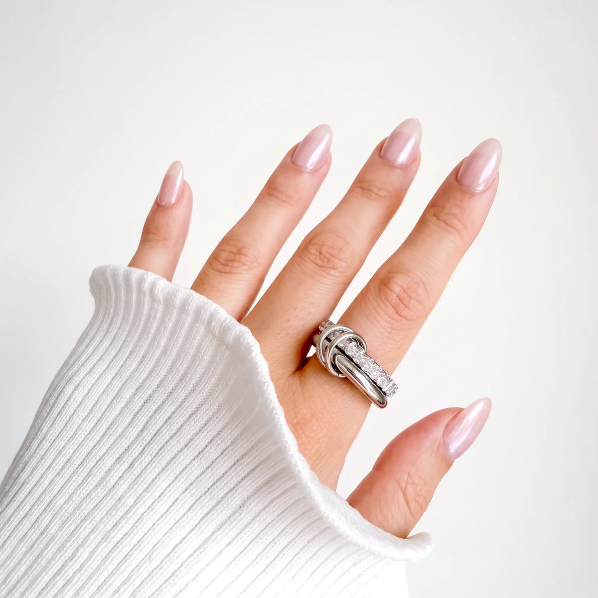 Sprinkled Donut Ring in silver worn on a woman's hand with a white ribbed knit sleeve