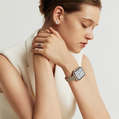 Woman wearing the Inspiration Apple Watch Band in silver, hands crossed at her shoulder in a cream top