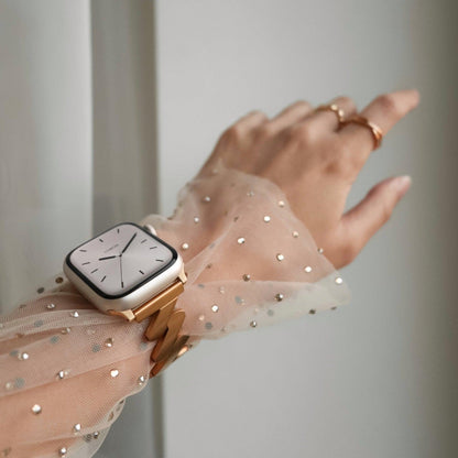 Lightning Apple Watch Band in 18k gold plated on a wrist under a sheer dotted tulle sleeve