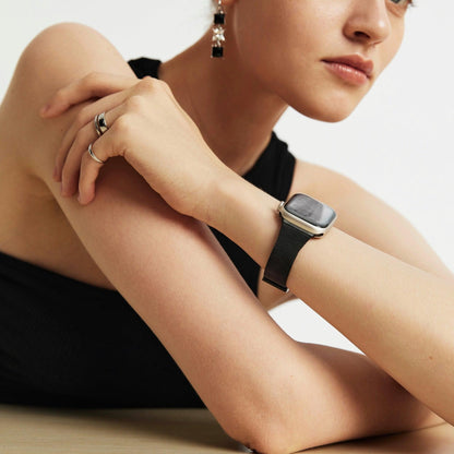 Woman wearing the Slim Milanese Apple Watch Band in black, hand on her shoulder in a black top