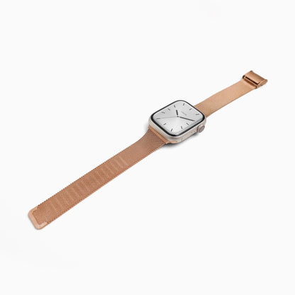 Slim Milanese Apple Watch Band in rose gold stainless steel mesh, laid at an angle on white