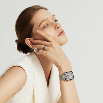 Woman wearing the Slim Milanese Apple Watch Band in silver, hand at her temple, hair in a bun