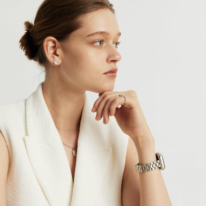 Woman wearing the Slim Oyster Apple Watch Band in silver, hand resting at her shoulder