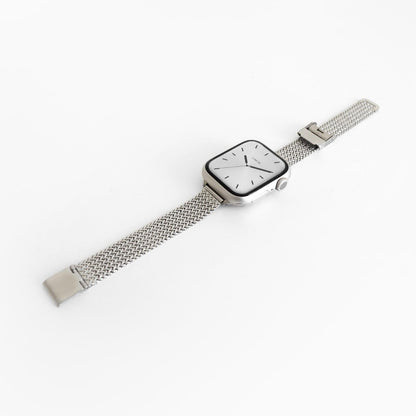 Slim Stellar Apple Watch Band in silver stainless steel mesh, angled view on white