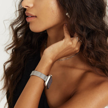 Slim Stellar Apple Watch Band in silver mesh worn on wrist, side profile of a woman