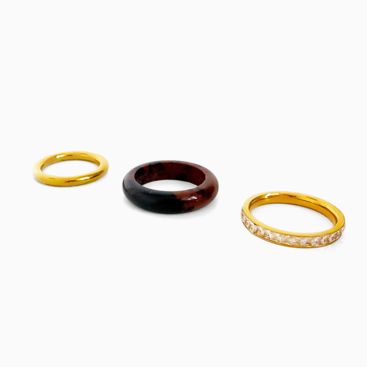 Tiramisu Ring Set laid out as three separate rings: smooth gold-tone ring, brown and black jasper band, and gold-tone rhinestone row band